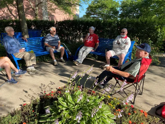 a group of older men enjoying coffee outside at the Y.