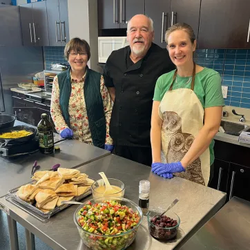 A group of presenters showing off their delicious fresh food.