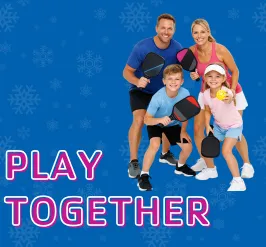 A family holding their pickleball paddles.