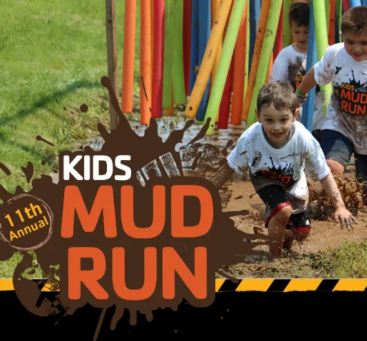 A group of kids running in a mud puddle. 11th annual kids mud run.