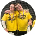 two boys with their arms around each other, showing their medals from the TOP soccer program.