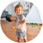 a little boy holding a colorful ball.