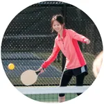 A woman hitting a pickleball.
