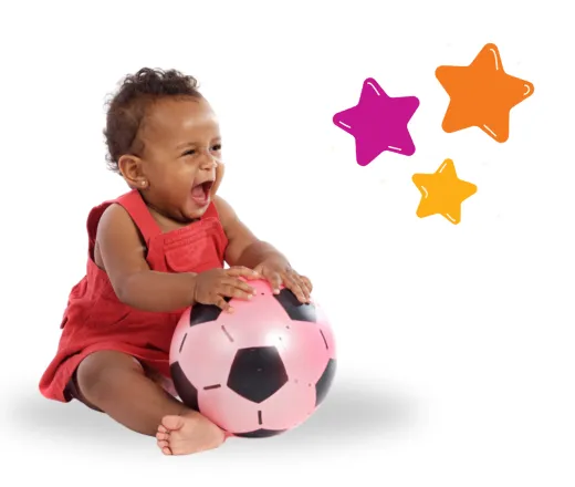 a happy baby holding a soccer ball.
