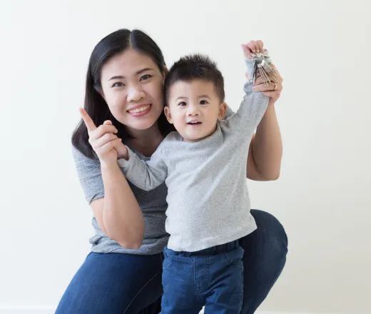 A mother smiling with her toddler.