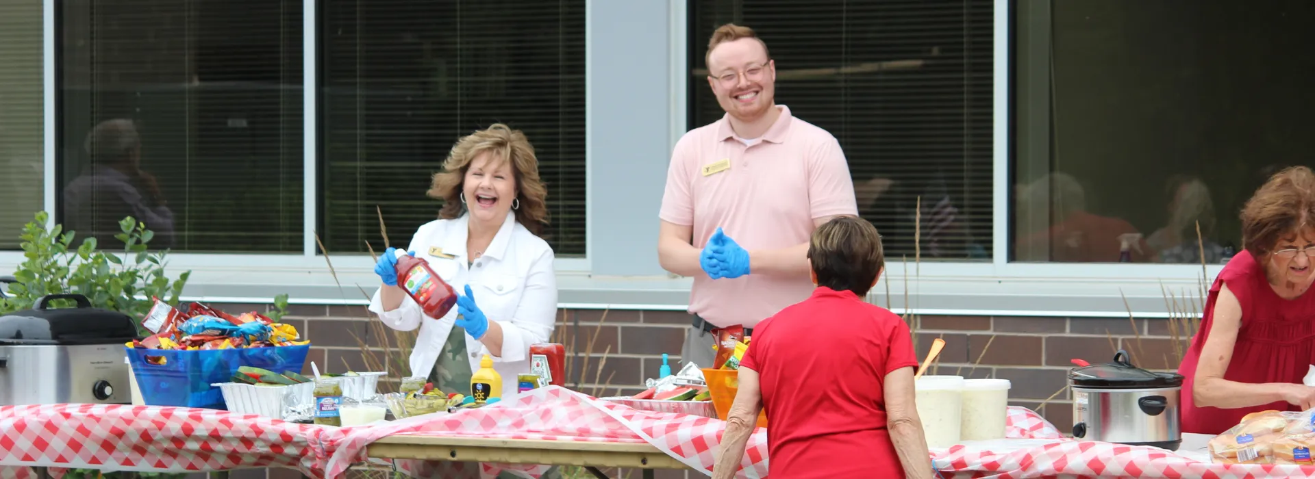Volunteers in action serving food and smiles at the senior picnic.