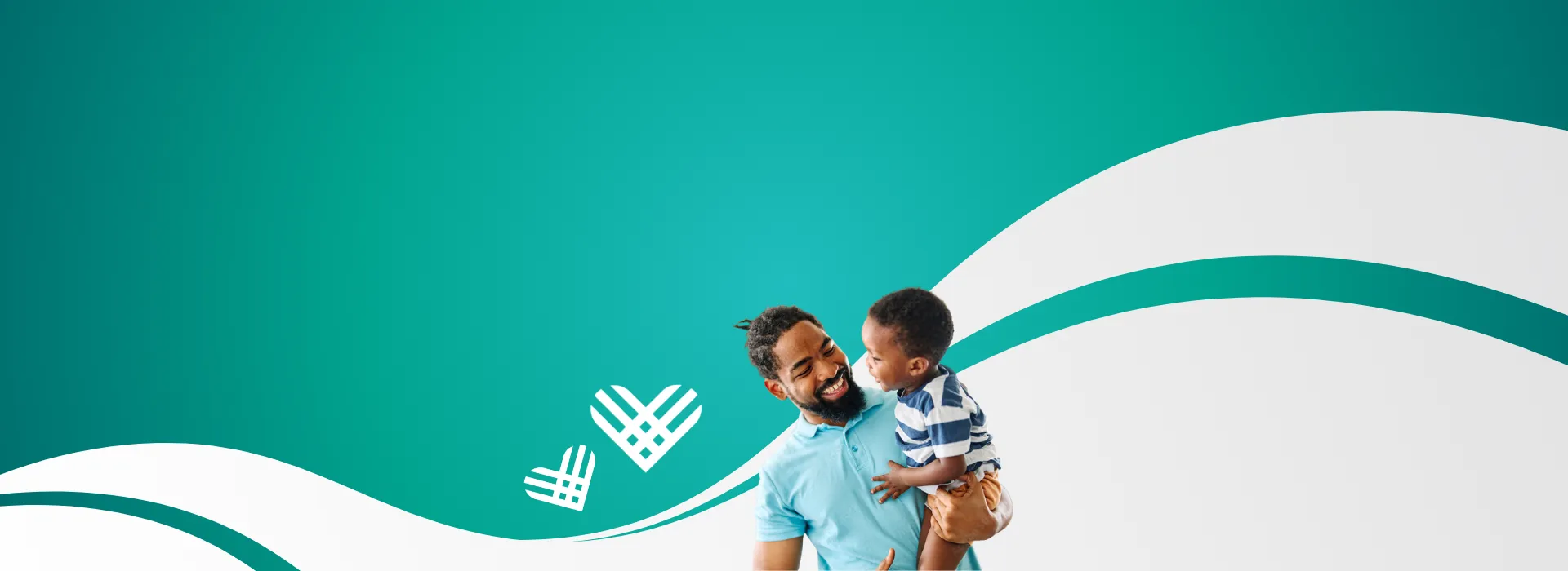 A smiling father holding his toddler son.